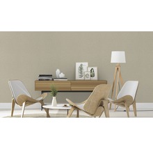 Wohnzimmer mit gemusterter Tapete, Holzmöbeln und Dekorationsartikeln