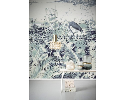 Dekoratives Wohnambiente mit gemusterter Tapete, Lampe, Tisch und Dekoration