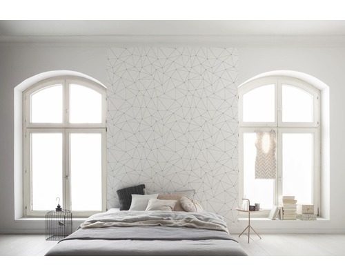 Schlafzimmer mit geometrischer Tapete, Bett und Fenstern