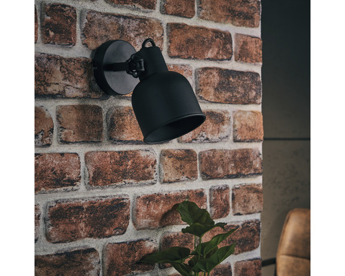 Schwarze Wandleuchte an einer Ziegelwand