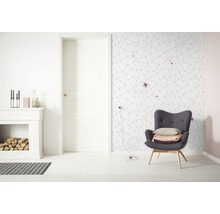 Heller Wohnraum mit Kamin, Sessel und geometrischer Tapete
