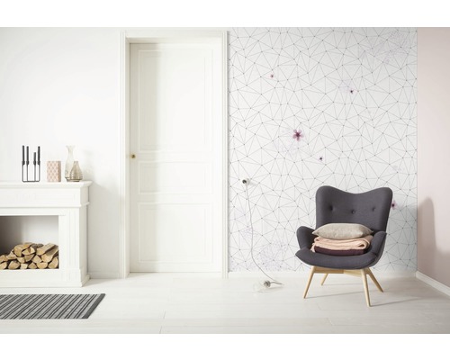 Heller Wohnraum mit Kamin, Sessel und geometrischer Tapete