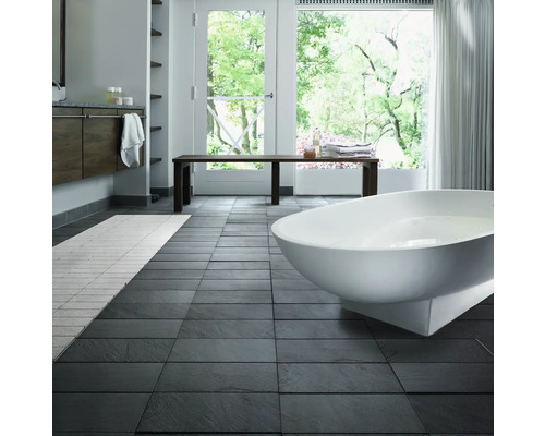 Helles Badezimmer mit Badewanne, Bank und dunklen Bodenfliesen