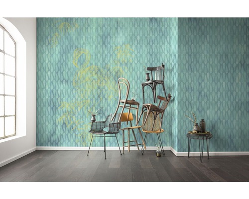 Raumansicht mit gemusterter Tapete, verschiedenen Stühlen und Beistelltisch