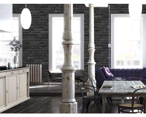 Heller Wohnraum mit Tapete in Steinoptik, Esstisch, Sofa und Säulen