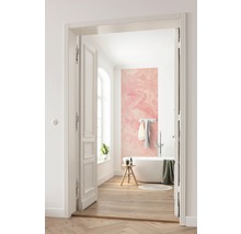 Badezimmer mit Badewanne, Hocker, Handtüchern und einer rosa Fototapete mit Drachenmotiv.