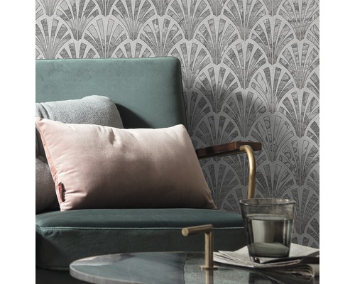 Szene mit Sessel, Kissen und gemusterter Tapete im Art-Déco-Stil