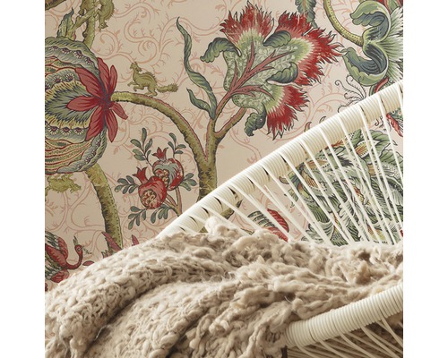 Detailansicht eines Raumes mit gemusterter Tapete, einem Sessel und einer Decke.