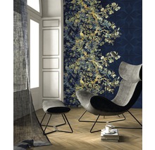 Wohnzimmer mit Sessel, Hocker und Wandtapete mit floralem Muster und Vogelmotiven.