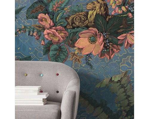 Gemusterte Tapete mit Blumen, Löwen und Tiger neben einem Sessel mit Büchern