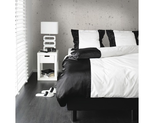 Schlafzimmer mit Bettwäsche, Nachttisch und Lampe