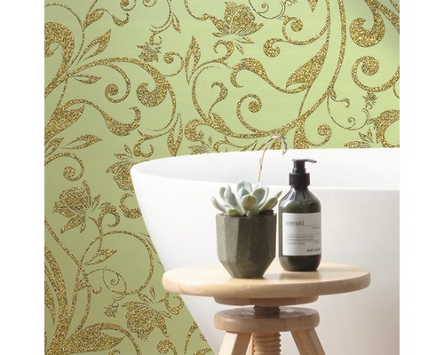 Dekorative Wandgestaltung mit floralem Tapetenmuster, Badewanne und Badezimmeraccessoires auf einem Hocker