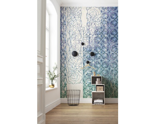 Zimmer mit floral gemusterter Tapete, schwarzem Drahtkorb und weißem Regal.