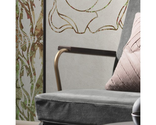 Detailaufnahme eines Sessels mit Kissen vor einer Wand mit floralem Muster