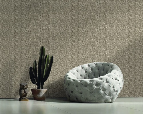Wohnraum mit Textiltapete, Sessel, Kaktus und Dekofigur