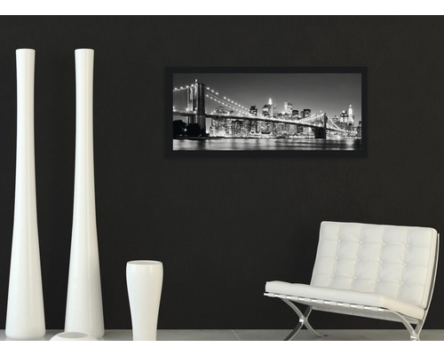 Dekoratives Wohnzimmer mit gerahmtem Bild einer Stadtlandschaft, weißen Vasen und einem Sessel