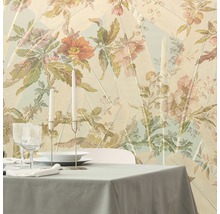 Gedeckter Esstisch vor einer floral gemusterten Tapete mit Blattmotiven.