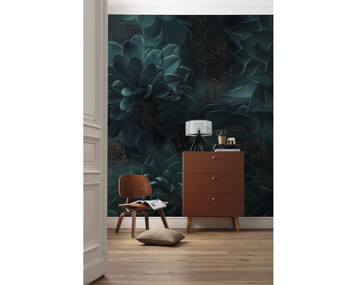 Dekoratives Zimmer mit einer Wandtapete mit Pflanzenmotiv, einer Holzkommode und einem Holzstuhl.