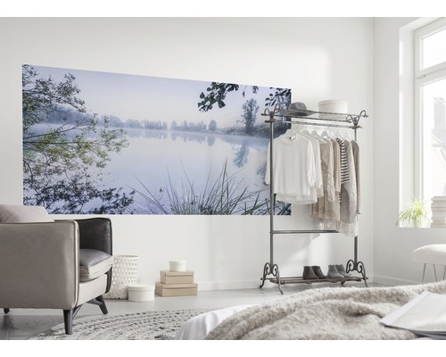 Wohnraum mit Wandbild eines Sees im Morgennebel, Sessel und Kleiderständer