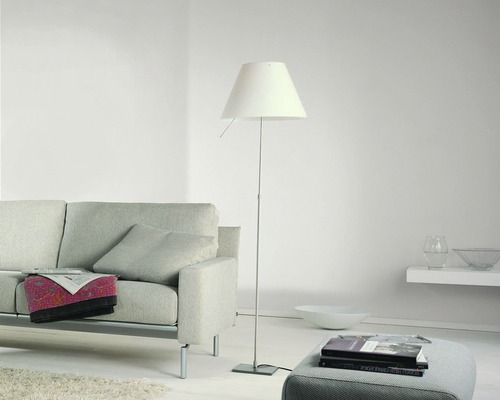 Wohnzimmer mit Stehlampe, Sofa und Hocker für ein helles und organisiertes Ambiente