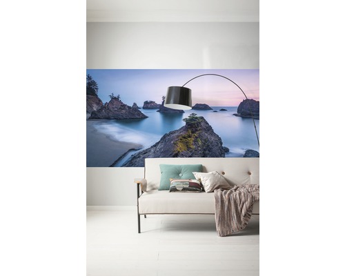 Wandbild mit Strandlandschaft über einem Sofa mit Stehlampe