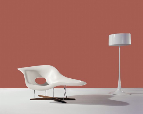 Szene mit Loungesessel aus Kunststoff, Metall und Holz sowie Stehlampe