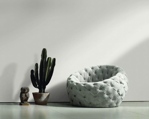 Wohnzimmer-Szene mit gepolstertem Sessel, Kaktus und dekorativer Eulenfigur