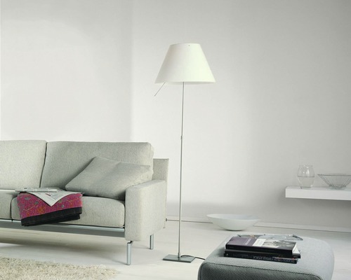 Wohnzimmer mit Sofa, Stehlampe und Hocker für eine helle und organisierte Atmosphäre.