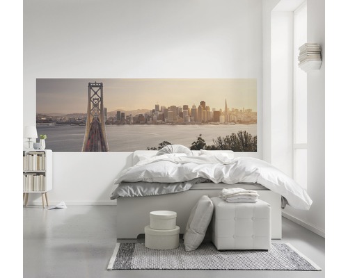 Helles Schlafzimmer mit Wandbild einer Stadtlandschaft, Bett und Nachttisch