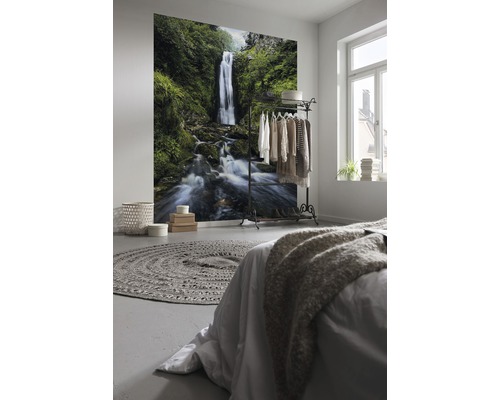 Schlafzimmer mit Fototapete eines Wasserfalls, Bett und Kleiderständer