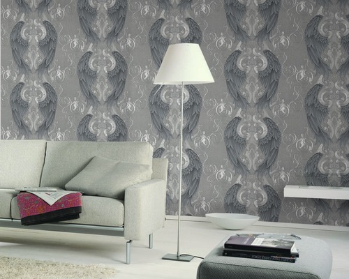 Wohnzimmer mit grauer Tapete mit Flügelmuster, Sofa und Stehlampe.