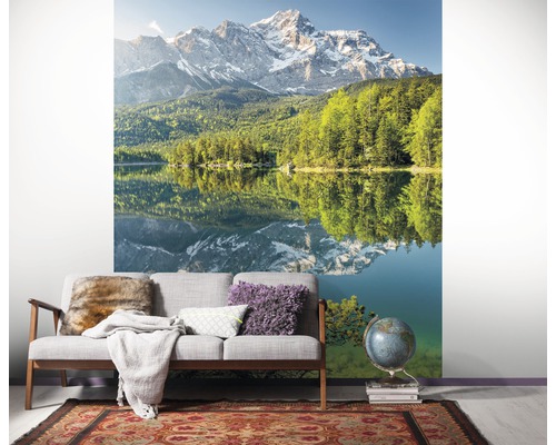 Wandbild mit Bergsee-Motiv in einem Wohnraum mit Sofa und Teppich