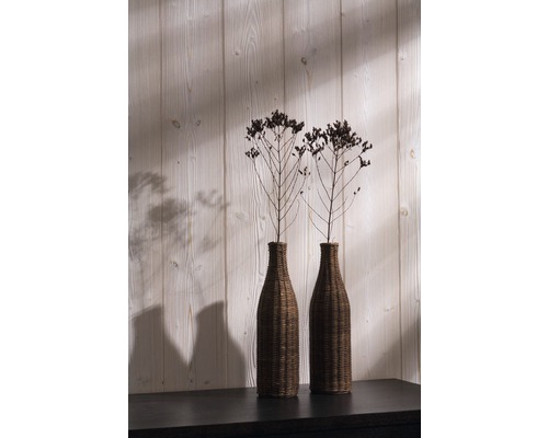 Zwei Dekovasen mit Pflanzen auf einem Tisch vor einer Holzwand