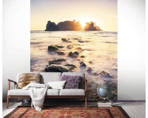 Raumszene mit Fototapete eines Strandes mit Felsen im Meer bei Sonnenaufgang