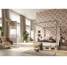 Helles Schlafzimmer mit Himmelbett, gemusterter Tapete und Rattanmöbeln für ein entspanntes Ambiente