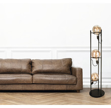 Wohnzimmer mit braunem Ledersofa und Stehlampe mit drei Leuchtmitteln