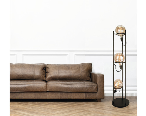 Wohnzimmer mit braunem Ledersofa und Stehlampe mit drei Leuchtmitteln