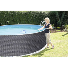 Frau reinigt einen runden Aufstellpool mit einem Kescher im Garten.