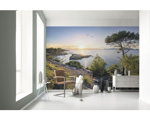 Helles Zimmer mit Fototapete einer Küstenlandschaft bei Sonnenuntergang