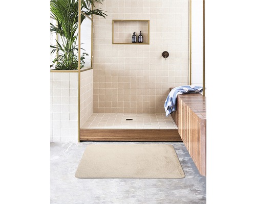 Beige Badematte im Badezimmer mit Dusche und Holzelementen.
