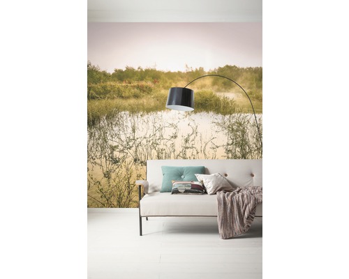 Wohnzimmer mit Sofa, Lampe und Fototapete mit Landschaftsmotiv