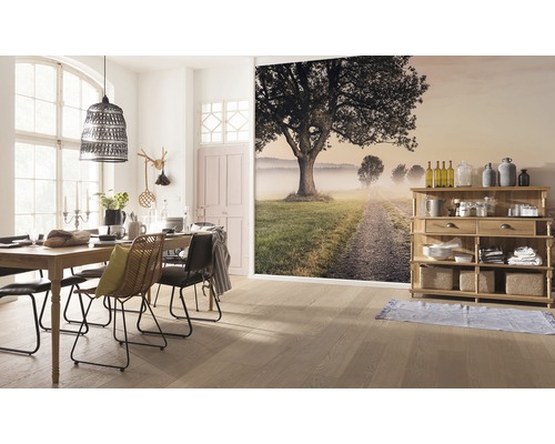 Esszimmer mit Holztisch, Stühlen, Lampe und Wandbild mit Landschaftsmotiv.