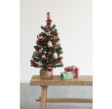 Dekorierter Weihnachtsbaum mit Geschenken auf einem Holztisch.