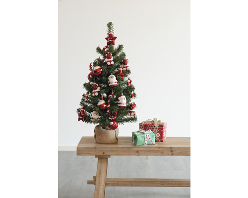 Dekorierter Weihnachtsbaum mit Geschenken auf einem Holztisch.
