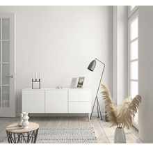 Heller Wohnraum mit Kommode, Stehlampe und Dekorationsartikeln