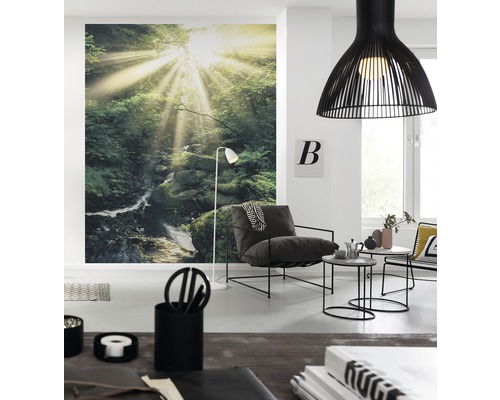 Wohnzimmer mit Waldtapete, Sessel, Lampe und Beistelltischen in hellem Ambiente