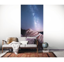 Wohnzimmer mit einer Fototapete mit einer Landschaft unter dem Sternenhimmel.