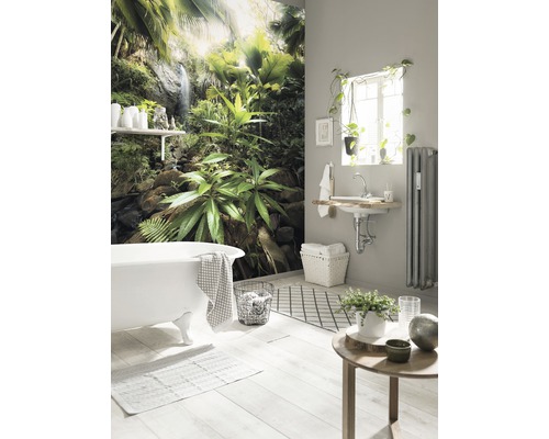Badezimmer mit Badewanne, Waschbecken, Heizkörper, Dekoration und Fototapete mit Dschungelmotiv für eine entspannende Atmosphäre