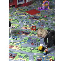 Kind spielt mit Spielzeugautos auf einem Teppich mit Stadtmotiv
