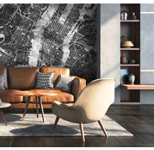 Wohnzimmer mit braunem Ledersofa, Sessel und Wandtapete mit Stadtplan